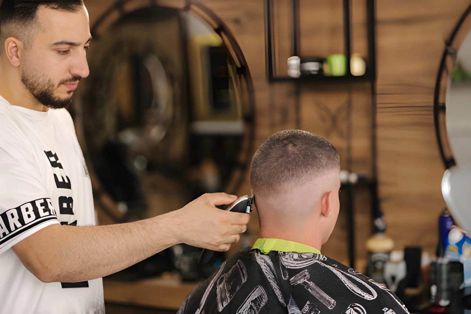 Back view of handsome hairdresser cutting hair of man